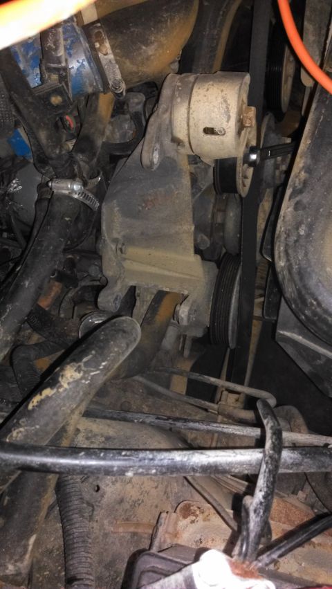 1990 Ford Bronco - Close-up of an engine's belt tensioner assembly and related components.