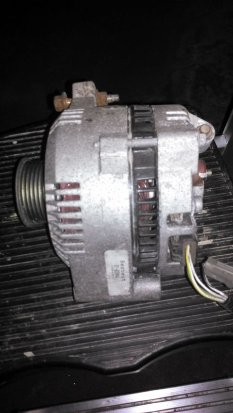 1990 Ford Bronco - A car alternator is shown, likely a replacement part, with visible labeling and electrical connections.