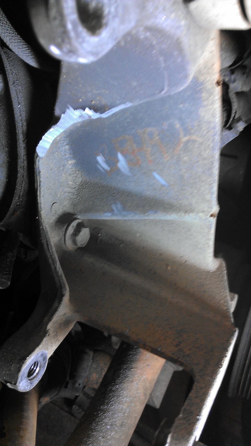 Damaged metal engine bracket with rust and bolt
