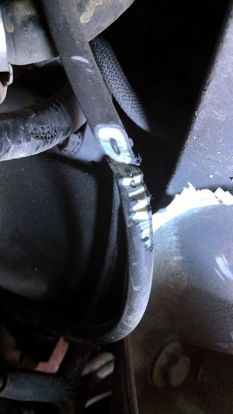 1990 Ford Bronco - A damaged hose with visible wear and tear, possibly a coolant or vacuum line.