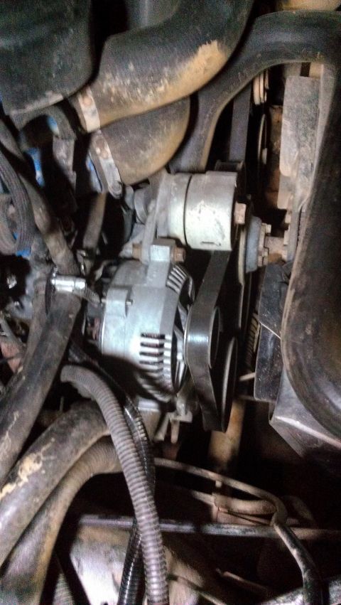 1990 Ford Bronco - Close-up view of an engine's alternator and associated components.