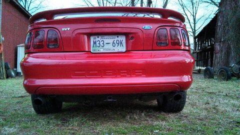 1997 Ford Mustang - Rear view of a red Ford Mustang Cobra with SVT badging and a Tennessee license plate.