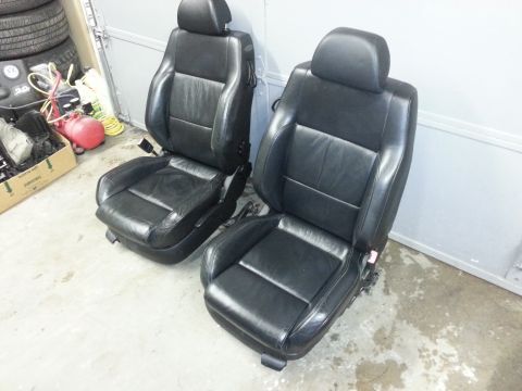 2002 Volkswagen Jetta - A pair of black leather car seats are shown, likely for sale or storage.