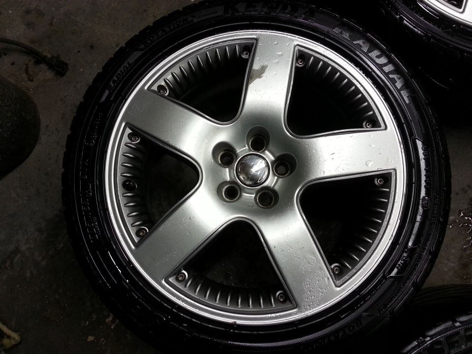 Silver five-spoke alloy wheel with a Volkswagen logo in the center, mounted on a tire
