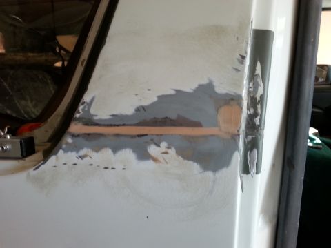 1992 Ford Bronco - This photo shows bodywork in progress on a vehicle, with primer and filler applied to the door jamb area.