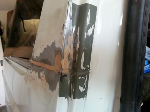 1992 Ford Bronco - Close-up of a vehicle body panel undergoing rust repair and bodywork.