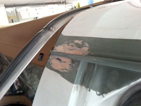 1992 Ford Bronco - Close-up of bodywork and primer on a vehicle's drip rail, indicating repair work.