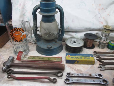 2004 Aston Martin Virage - Various tools and a vintage lantern are laid out on a patterned cloth surface.