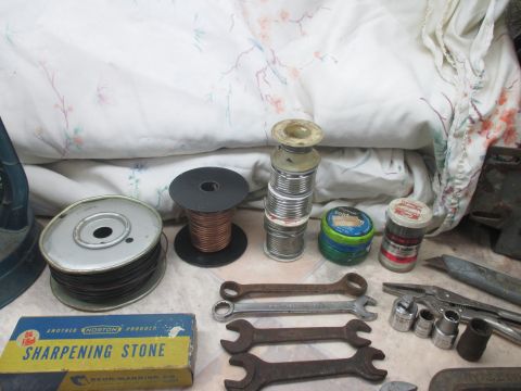 2004 Aston Martin Virage - Collection of tools and soldering supplies including wire, solder, wrenches, and a sharpening stone.