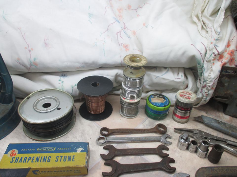 Spool of copper wire, spools of solder, sharpening stone box, and wrenches