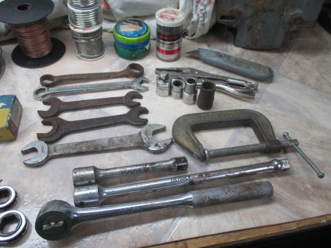 2004 Aston Martin Virage - A collection of various hand tools, including wrenches and sockets, are laid out on a table.