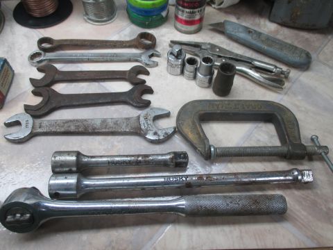 2004 Aston Martin Virage - A collection of various hand tools, including wrenches and sockets, are laid out on a surface.
