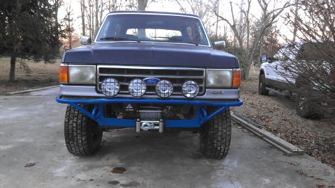 1990 Ford Bronco - This Ford truck features a custom blue front bumper with an integrated winch and auxiliary lights.