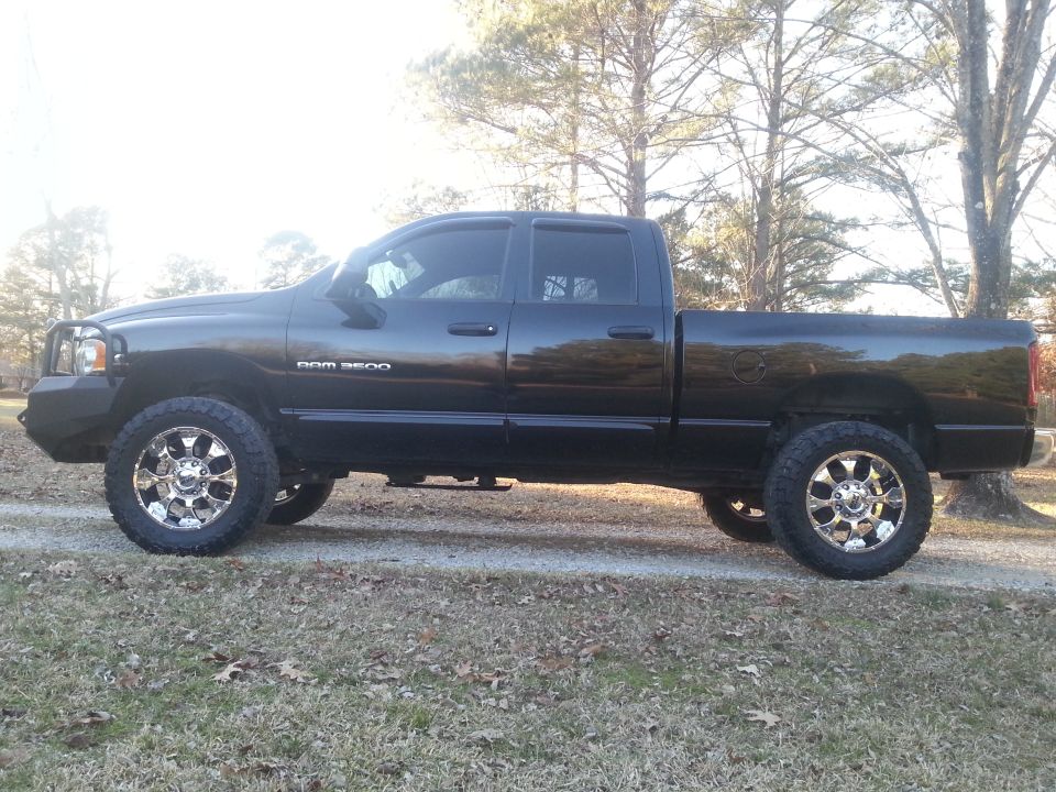 Black Dodge Ram 3500 pickup truck, side view, with chrome wheels