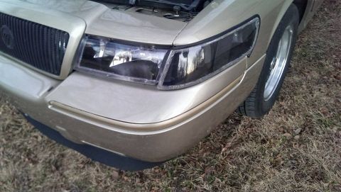 2000 Mercury Grand Marquis - Front corner view of a 2000 Mercury Grand Marquis, showing the headlight and grille.