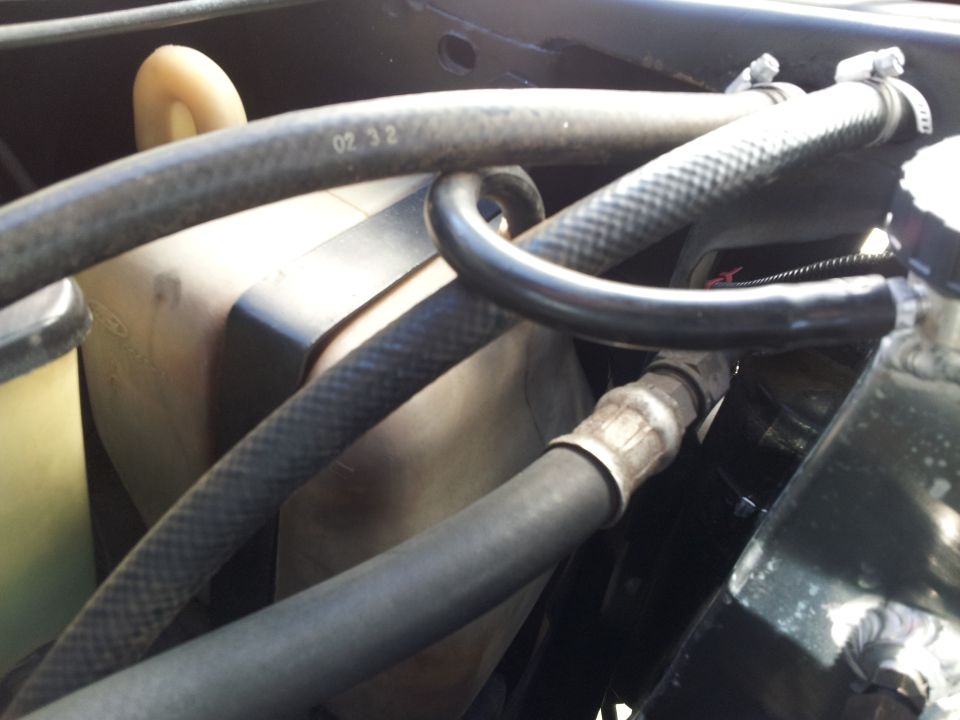 Radiator hoses and coolant reservoir with visible text '02 32' on a hose