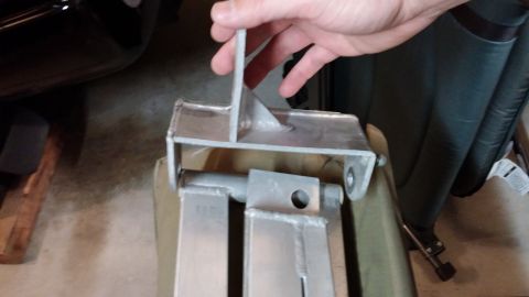 1985 Toyota 4Runner - A person holds a metal bracket assembly with visible bolts and mounting holes.