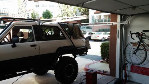 1985 Toyota 4Runner - A modified SUV is parked in a garage, with a bicycle mounted on the wall and other vehicles in the background.