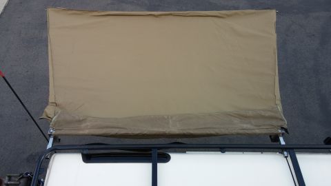 1985 Toyota 4Runner - A tan awning is deployed from the side of a vehicle's roof rack.