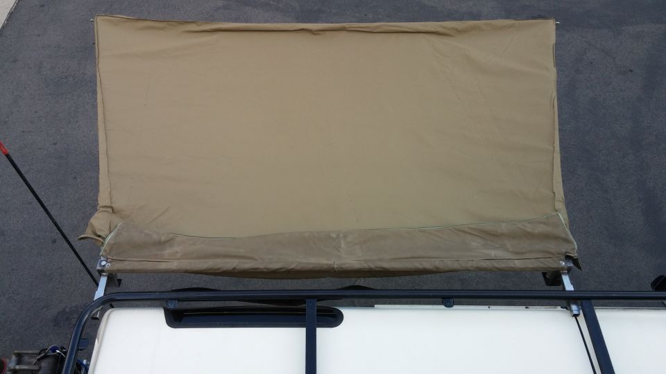 tan car awning extended over roof rack