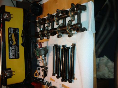 1985 Toyota 4Runner - Engine parts, including rocker arms and bolts, are organized on a workbench for a rebuild.
