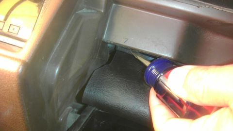 1985 Toyota 4Runner - A hand is shown prying open a dashboard panel in a 1985 Toyota 4Runner.