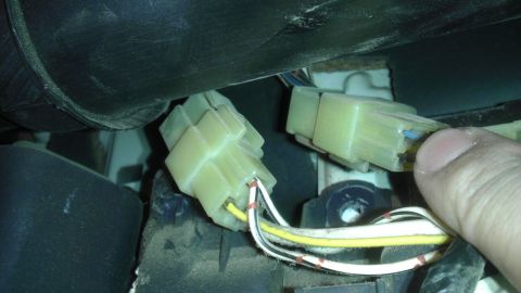 1985 Toyota 4Runner - A hand manipulates electrical connectors and wiring, likely for an A/C installation.