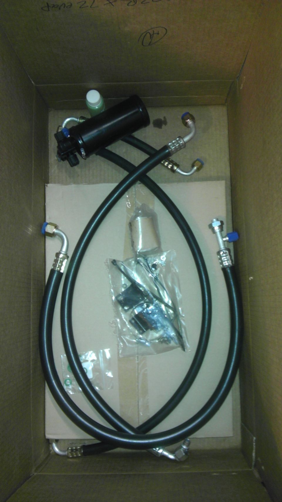 Black AC receiver drier and hoses in a cardboard box
