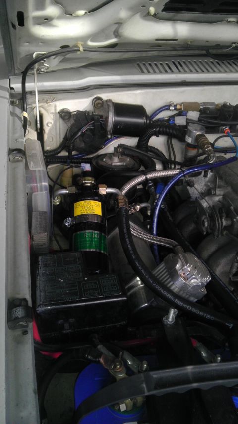 1985 Toyota 4Runner - Close-up view of engine bay components, including an A/C receiver-drier and associated plumbing.