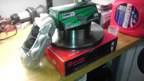 2000 Toyota 4Runner - Brake caliper, rotor, and Hawk LTS pads are displayed on a shelf, ready for installation.