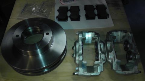 2000 Toyota 4Runner - New brake rotors, calipers, and pads laid out on a wooden surface.
