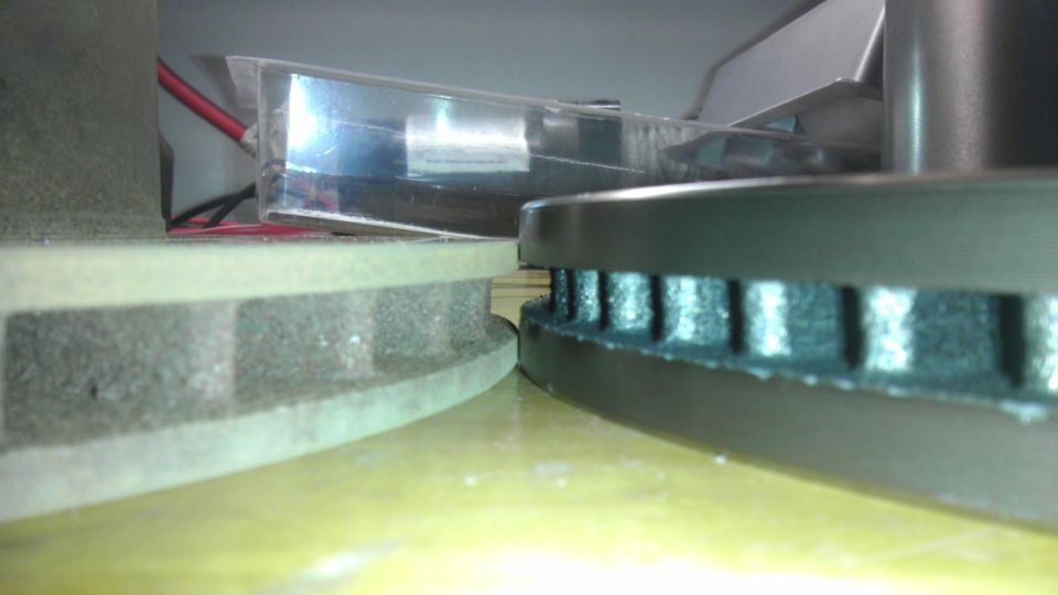 Two brake rotors, one with ventilation slots, on a yellow surface