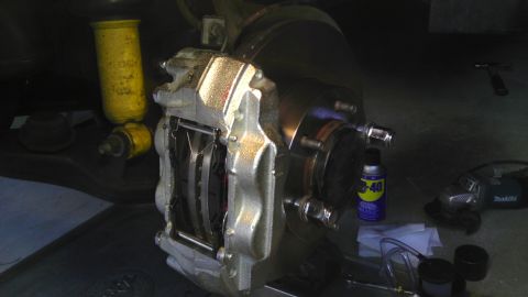 2000 Toyota 4Runner - Close-up view of a vehicle's brake caliper and rotor assembly, with a yellow shock absorber visible in the background.