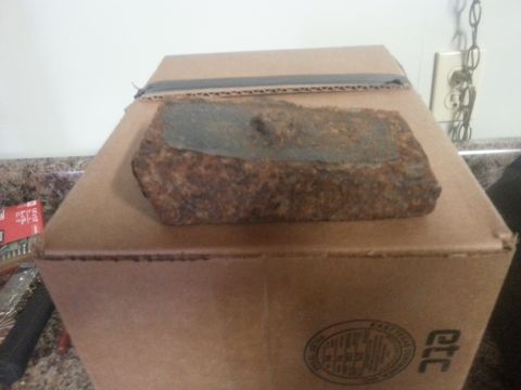 1996 Ford Bronco - A rusty metal part sits on a cardboard box with Supermotors branding.