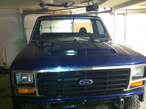 1982 Ford Bronco - Front view of a blue 1982 Ford Bronco, a prominent Ford emblem on the grille and a hood scoop.
