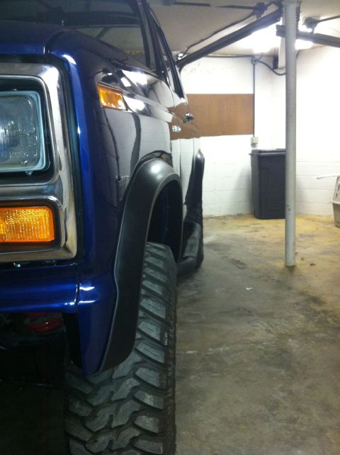 1982 Ford Bronco - Close-up view of the front fender and large tire on a blue 1982 Ford Bronco.
