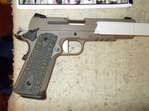 2012 Ford Mustang - A tan pistol with a textured grip is shown with white tape on its slide.