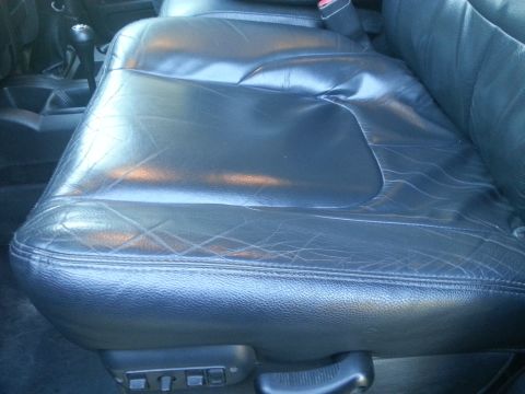 1967 Ford Mustang - Interior view of a worn black leather car seat with diamond stitching and power seat controls visible.