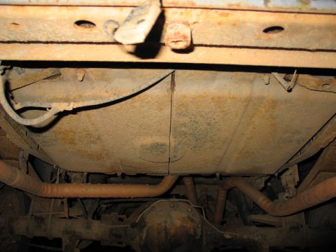 1995 Ford Bronco - The undercarriage of this vehicle displays significant rust and wear on its fuel tank and exhaust components.