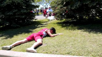 2000 Mercury Grand Marquis - A person is lying on the grass in a park-like setting, with other people visible in the background.