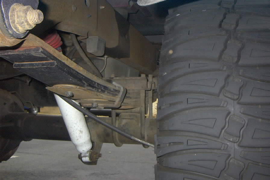 Close-up of a large tire and rear suspension components, possibly from a truck or SUV