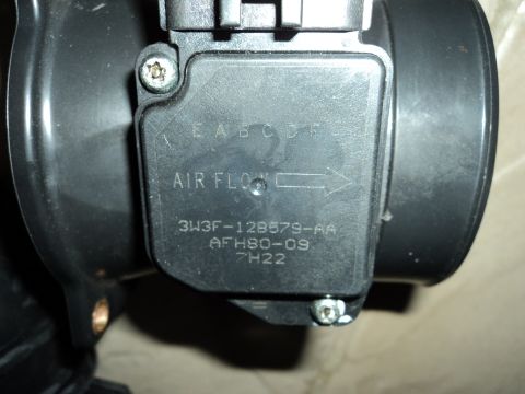 2004 Mercury Grand Marquis - Close-up of a vehicle's mass air flow sensor, showing part numbers and air flow direction.