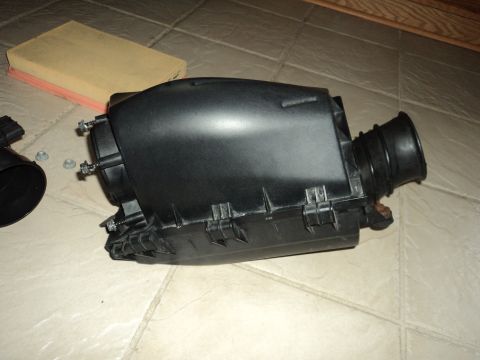 2004 Mercury Grand Marquis - Air filter housing and filter on a tiled surface.