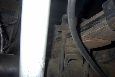 1994 Ford Bronco - Detail shot of a vehicle's suspension components, focusing on the leaf spring and shock absorber.