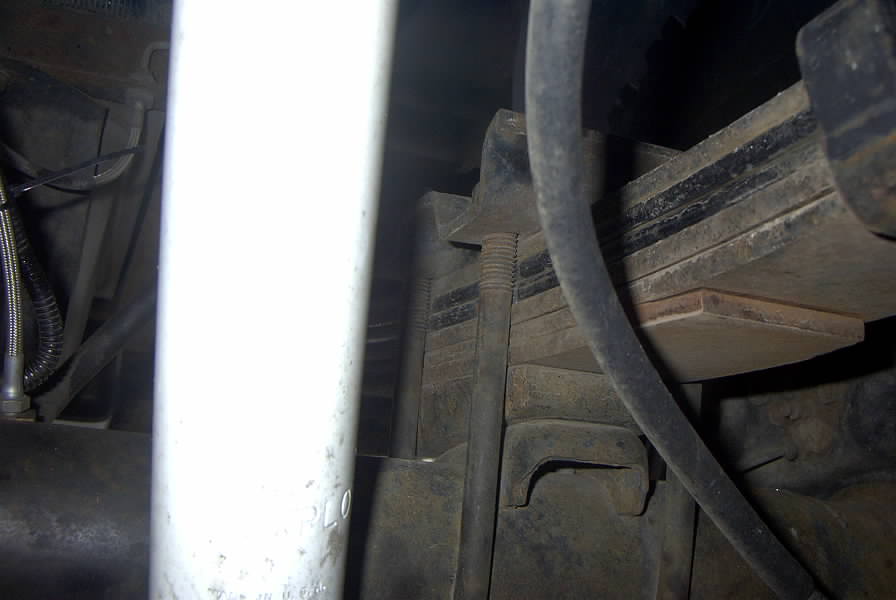 Close-up of a vehicle's leaf spring and shock absorber assembly