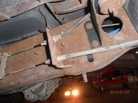 1996 Ford Bronco - Close-up of the undercarriage, showing the frame, brake lines, and differential of a vehicle.