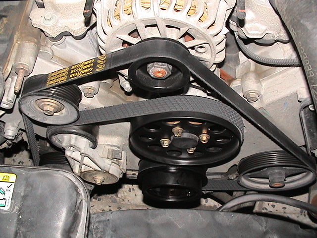 Engine bay serpentine belt routing over alternator, idler, and water pump pulleys
