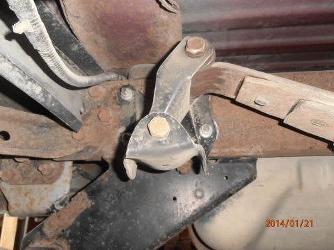1996 Ford Bronco - Underside view of a vehicle's rusty suspension system, showing metal brackets and bolts.