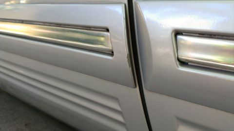 1996 Lincoln Town Car - Detail of the side door trim on a 1996 Lincoln Town Car, showing the chrome accent and ribbed lower section.