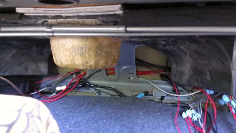 1996 Lincoln Town Car - Exposed wiring and a subwoofer enclosure are visible in the trunk of a car.